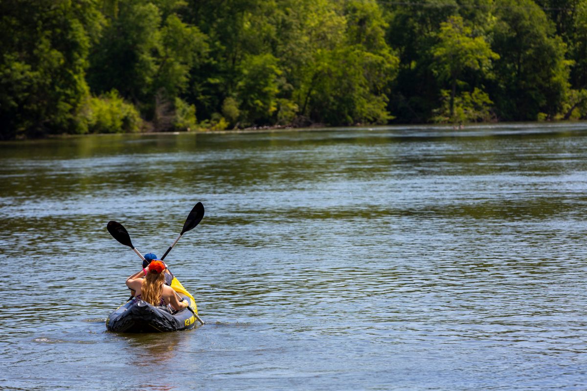 Two people from behind paddling a kayak